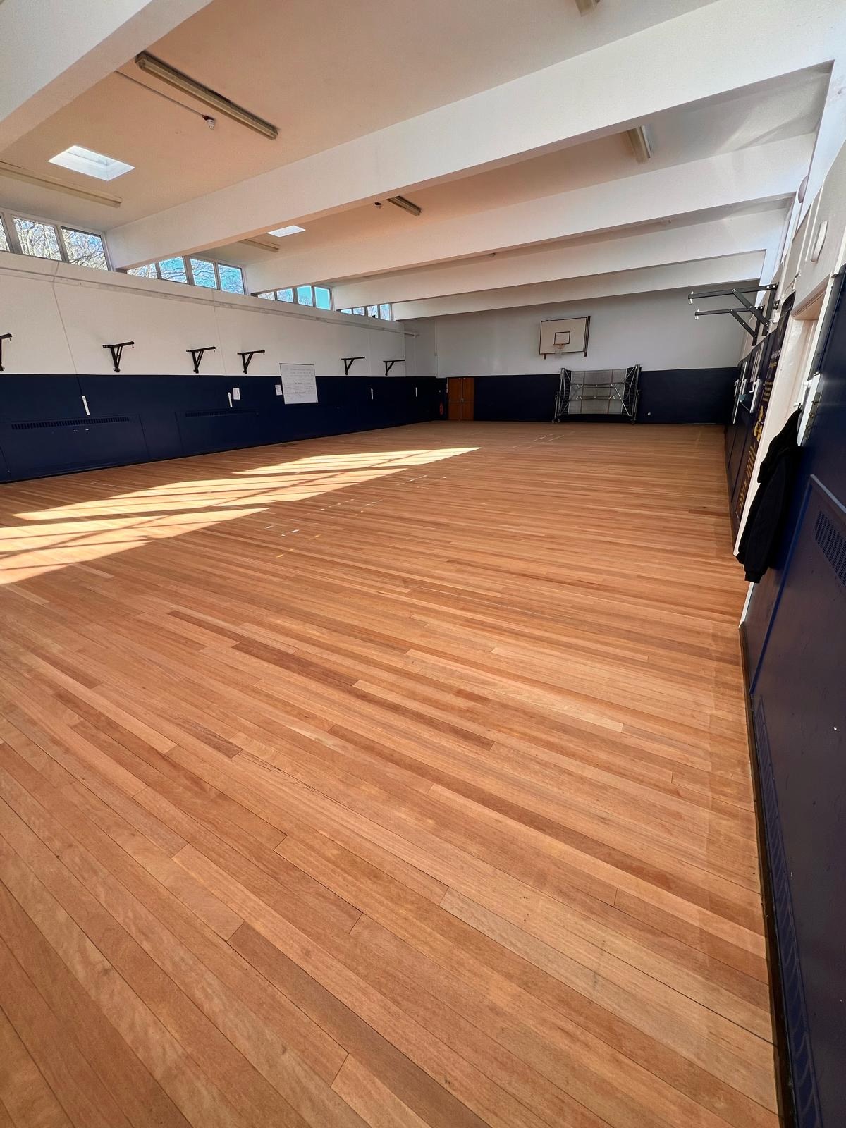 School sports hall floor sanded back to bare timber before new lines and lacquer